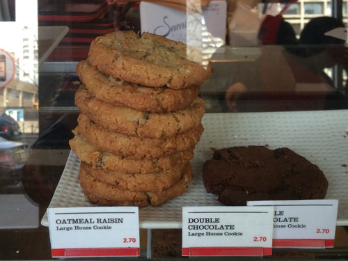 Two stacks of cookies in a bakery display. The stack on the left is much taller.