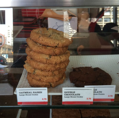 Two stacks of cookies in a bakery display. The stack on the left is much taller.